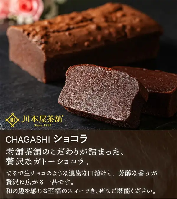 川本屋茶舗 濃厚ガトーショコラ(巧克力蛋糕)整个装的商品照片。黑色石板上摆放着一整条细长的巧克力蛋糕和两块展示切面的切块,左上角有粉色花朵。左下角为店铺标志「川本屋茶舗 Since 1897」。图片内为店铺自行加入的文字:「CHAGASHI ショコラ」「老舗茶舗のこだわりが詰まった、贅沢なガトーショコラ。」(凝聚老字号茶铺心意的奢华巧克力蛋糕)「まるで生チョコのような濃密な口溶けと、芳醇な香りが贅沢に広がる一品です。」(如生巧克力般浓密的入口即化口感与醇香的一品)「和の趣を感じる至福のスイーツを、ぜひご堪能ください。」(请品尝这款带有和风韵味的幸福甜点)。