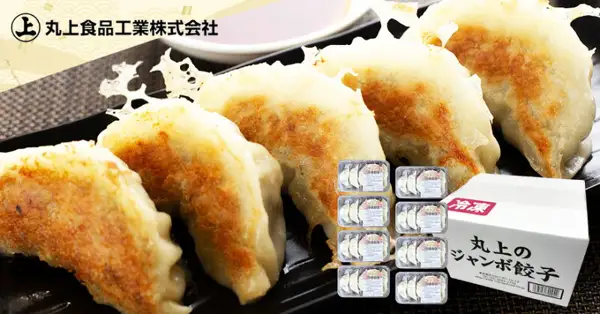 Product photo of 丸上食品 Jumbo Gyoza, 40 pieces (5 pieces x 8 packs). In front of 5 pan-fried gyoza arranged in a black bowl are 8 trays of 5 pieces each and a white box with a “冷凍” (frozen) tag and the text “丸上のジャンボ餃子” (Marujo’s Jumbo Gyoza). The shop logo “丸上食品工業株式会社” is at the top left. A small dish holding a sauce-like liquid is visible behind the bowl.