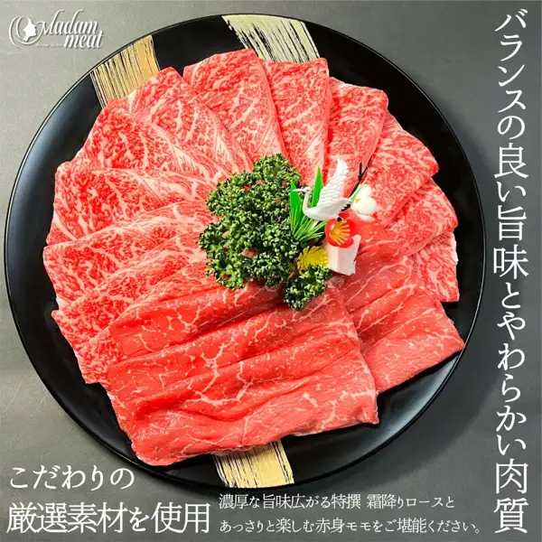 Product photo of sliced marbled loin and lean momo arranged in a flower shape on a round black plate, with parsley and a crane-shaped ornament in the center (Madam meat Tokusen Kuroge Wagyu marbled loin & domestic Japanese beef lean momo 400g). Shop logo “Madam meat” at the upper left. Text the shop placed in the image: “バランスの良い旨味とやわらかい肉質” (well-balanced umami and tender meat), “こだわりの厳選素材を使用” (made with carefully selected ingredients), “濃厚な旨味広がる特撰 霜降りロースとあっさりと楽しむ赤身モモをご堪能ください。” (enjoy the rich-umami Tokusen marbled loin and the light lean momo)