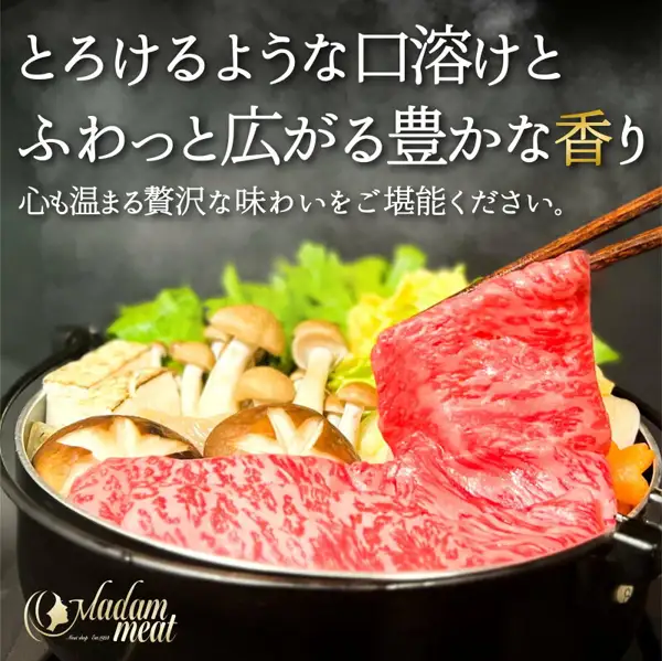 黑色锅中的寿喜烧，用筷子夹起肉片的盛盘示例照片（Madam meat 雪花里脊＆瘦肉后腿肉 对比品尝套装 400g）。锅中还有蘑菇、豆腐、青菜和胡萝卜。右下角有店铺标志“Madam meat”。店铺在图片中加入的文字：“とろけるような口溶けとふわっと広がる豊かな香り”（入口即化的口感与柔和扩散的浓郁香气）、“心も温まる贅沢な味わいをご堪能ください。”（请品尝温暖人心的奢华美味）
