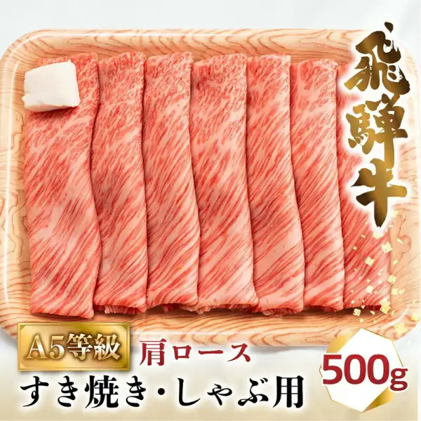 木目調の薄橙色のトレーに霜降りの牛肩ロースの薄切り7枚が並び、左上に白い脂の塊が写る商品写真（肉の匠家 飛騨牛 肩ロース すき焼き・しゃぶしゃぶ用 500g）。店舗が画像に入れた表示として「飛騨牛」「A5等級」「肩ロース」「すき焼き・しゃぶ用」「500g」の文字