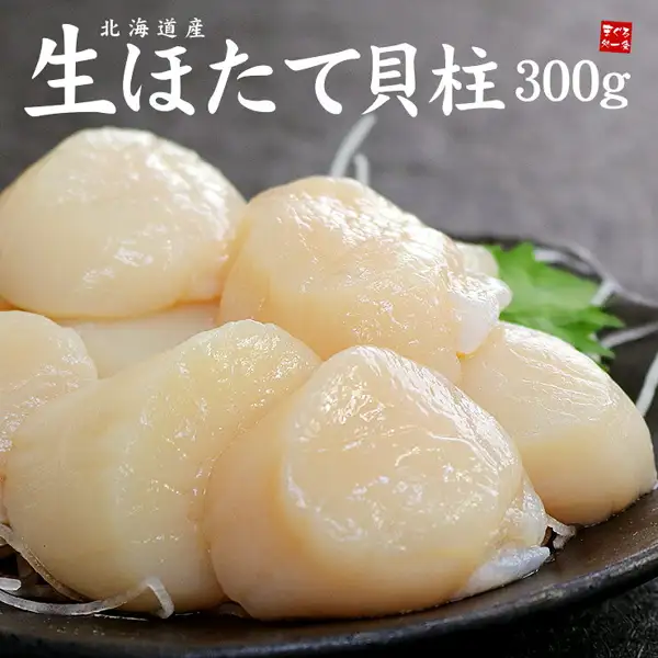 ほたて貝柱(扇贝柱)的商品照片(まぐろ処一条 北海道产 生ホタテ貝柱 300g):黑色圆盘中搭配萝卜丝和紫苏叶盛放的扇贝柱。店铺在图片中加入的文字:“北海道産”“生ほたて貝柱”“300g”,以及店铺标志“まぐろ処一条”