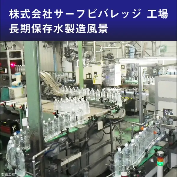 工場の製造ラインで、多数のペットボトルがコンベアの上を運ばれている写真（サーフビバレッジ 5年保存水 2L×6本の商品ページに掲載された画像）。店舗が画像に入れた表示「株式会社サーフビバレッジ 工場」「長期保存水製造風景」「製造工程」。