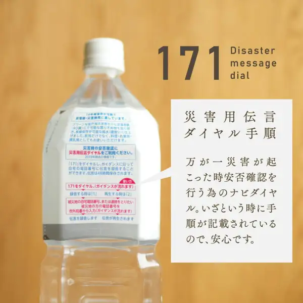 アコール 10年保存水 1.8L塑料瓶标签部分的特写商品照片,标签上印有灾害用留言电话171的使用步骤。图片内为店铺自行加入的文字:「171 Disaster message dial」「災害用伝言ダイヤル手順」「万が一災害が起こった時安否確認を行う為のナビダイヤル。いざという時に手順が記載されているので、安心です。」(大意:万一发生灾害时用于确认平安的导航拨号,步骤已印在瓶上,令人安心)。