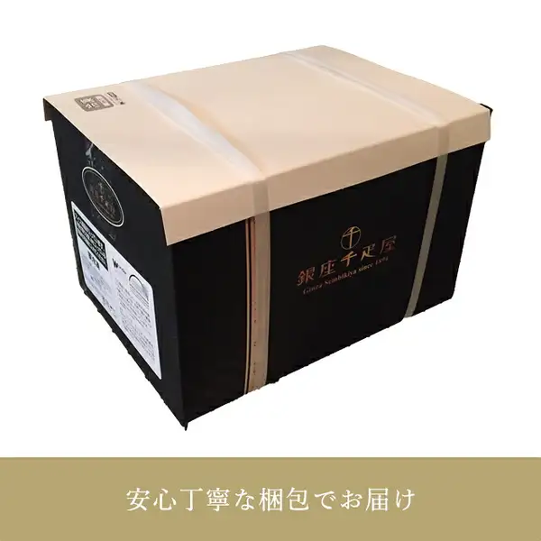 Photo of a black box covered with a cream-colored wrapper and fastened with 2 white bands. The front of the box carries the shop's logo “銀座千疋屋” and “Ginza Sembikiya since 1894”, there are white labels on the side, and the band at the bottom of the image reads “安心丁寧な梱包でお届け” (text the shop placed in the image). Ginza Premium Ice & Sorbet, 8 Pieces (パティスリー銀座千疋屋)