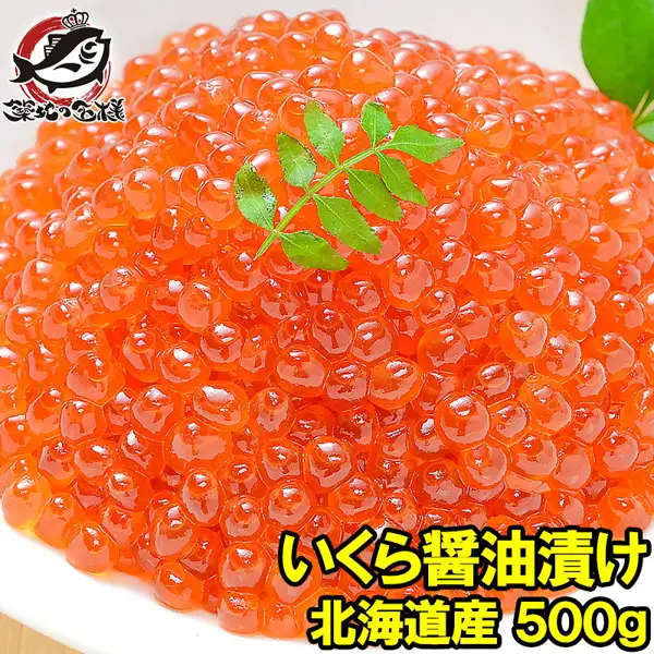 白色盘子里堆成小山的酱油渍鲑鱼子，配有装饰用的叶子的商品照片（築地の王様 イクラ醤油漬け（鲑鱼子酱油渍）500g 北海道产鲑鱼子）。左上角有店铺标志“築地の王様”。店铺加在图片上的标示为“いくら醤油漬け”“北海道産 500g”