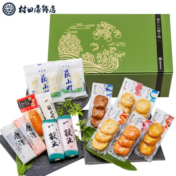 緑色の化粧箱の手前に、かまぼこ（一萩王・銀浪）・ちくわ・天ぷらの個包装が並んだ商品写真（村田蒲鉾店 萩からの贈り物 深緑（しんりょく））。店舗が画像に入れた表示「村田蒲鉾店」「萩からの贈り物」