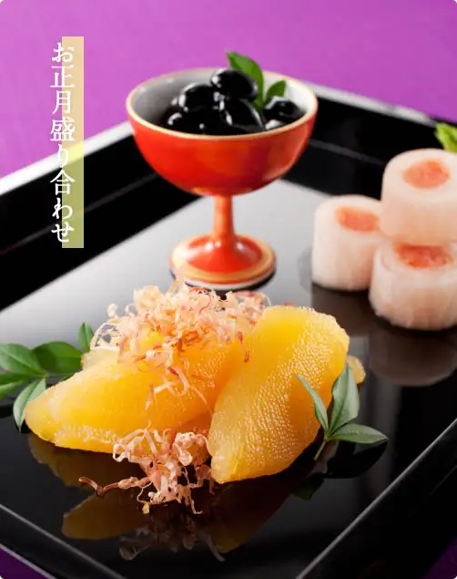 Serving example photo for Masuyone Seasoned Herring Roe (Kazunoko) “Honchan” 450g (150g × 3 bags): on a black lacquer tray, two pieces of herring roe topped with bonito flakes, black beans in a red cup, and white round-sliced roll-style dishes (the black beans, roll-style dishes, tray, cup and bonito flakes are not included). The text in the image was added by the store: “お正月盛り合わせ” written vertically at the upper left.