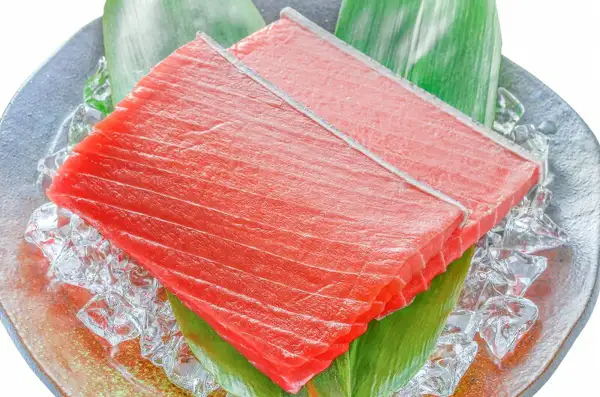 築地の王様 極上 本まぐろ 中トロ 400gの内容を示す商品写真。氷と笹の葉を敷いた青灰色の皿に、赤い中トロのサクが2つ重ねて置かれている