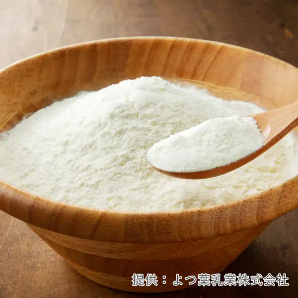 木碗中堆得满满的白色粉末,以及木勺舀起的粉末的照片。右下角有店铺加在图片中的标示“提供:よつ葉乳業株式会社”。ママパン 北海道脱脂奶粉(スキムミルク)400g