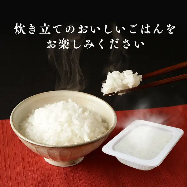 アイリスオーヤマ 低温製法米のおいしいごはん 180g×40食の商品写真。黒い背景で、白いご飯を盛った陶器の茶碗から湯気が立ち、箸でひとくち分をつまみ上げている。右手前に、湯気の立つ白いトレー入りのご飯。店舗が画像に入れた表示として「炊き立てのおいしいごはんをお楽しみください」の文字。
