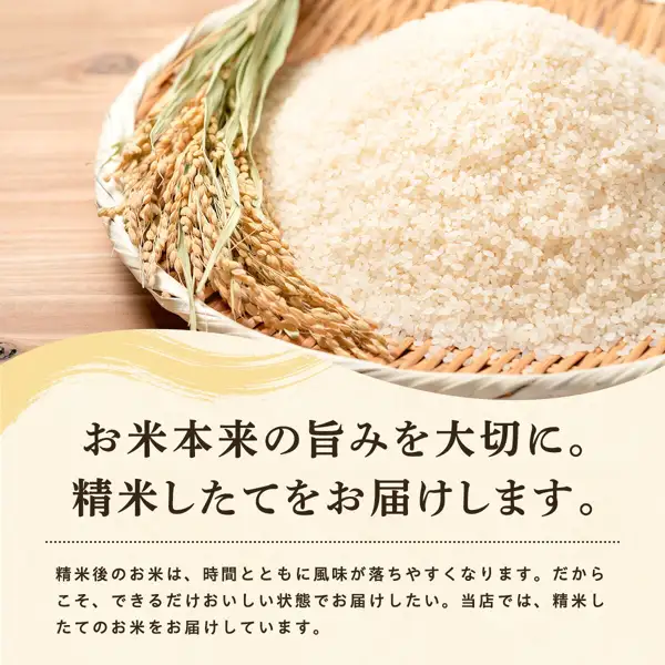 Store-supplied photo for Reiwa 8 Crop Akitakomachi Kakei Otasuke Rice: white rice heaped in a bamboo basket with a stalk of rice ears laid beside it, on a wooden surface. Text the shop placed in the image: "お米本来の旨みを大切に。精米したてをお届けします。" (Cherish the rice's natural flavor. We deliver freshly milled rice.) and "精米後のお米は、時間とともに風味が落ちやすくなります。だからこそ、できるだけおいしい状態でお届けしたい。当店では、精米したてのお米をお届けしています。" (Rice loses flavor over time after milling, so we want to deliver it in the best possible condition; we deliver freshly milled rice).