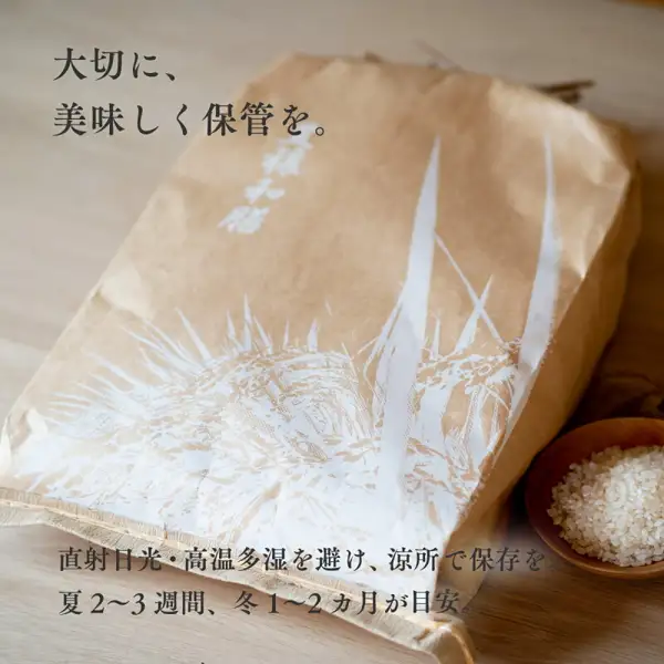 丸吉茅野商店 松岡さんのゆめぴりか 10kg の商品ページにある、木の台に置いたクラフト紙の米袋と、右下の木の小鉢に入れた白米の写真。店舗が画像に入れた表示：「大切に、美味しく保管を。」「直射日光・高温多湿を避け、涼所で保存を。」「夏2〜3週間、冬1〜2ヵ月が目安。」