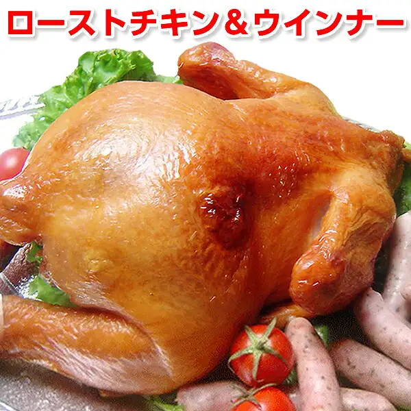 サンライズファーム ローストスモークチキン 丸鶏一羽：丸ごと1羽のローストスモークチキンに、ウインナー数本・ミニトマト・レタスを添えて銀色の皿に盛った盛り付け例の商品写真。画像上部に店舗が画像に入れた表示「ローストチキン＆ウインナー」。ミニトマト・レタスは商品に含まれません。ウインナーは種類がお楽しみのため、写真と届く種類が異なることがあります