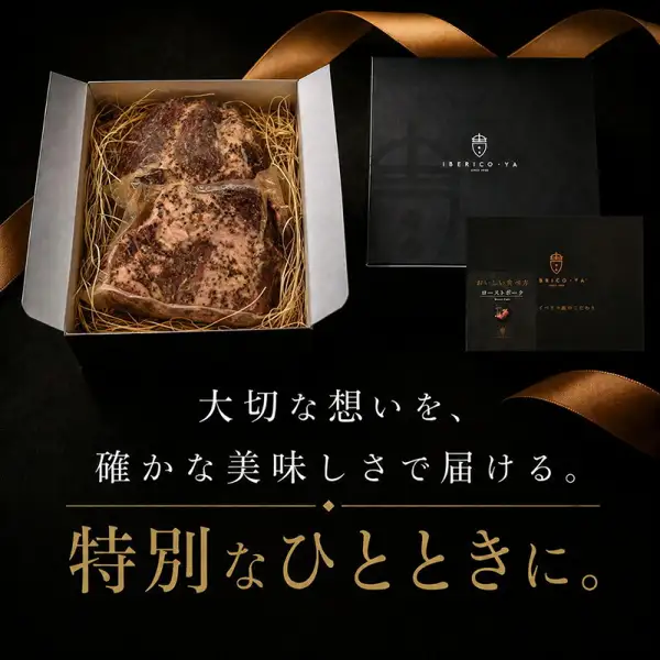 わらを敷いた箱の中にローストポークのブロック2個が収まっている様子と、奥に置かれた黒い外箱と冊子の写真（イベリコ屋 イベリコ豚 ローストポーク 280g×2個 化粧箱入りの中身）。店舗が画像に入れた表示「大切な想いを、確かな美味しさで届ける。特別なひとときに。」「IBERICO·YA」「おいしい食べ方 ローストポーク」「イベリコ豚のこだわり」