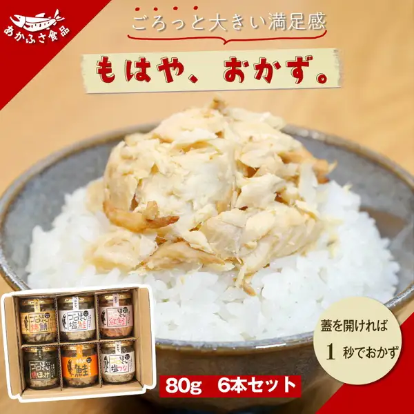 Product image of the Salmon Flakes ゴロほぐし (Chunky Flaked) 80 g 6-Jar Set (あかふさ食品) (a serving example; the rice and bowl are not included). Large whitish flaked fish piled on a bowl of rice, with a box holding six jars (labels 焼鯖, 塩鮭, 紅鮭, 焼ほっけ, the 鮭, 塩つな) at lower left. Store logo “あかふさ食品” at upper left. Text the store put on the image: “ごろっと大きい満足感”, “もはや、おかず。”, “蓋を開ければ1秒でおかず”, “80g 6本セット”