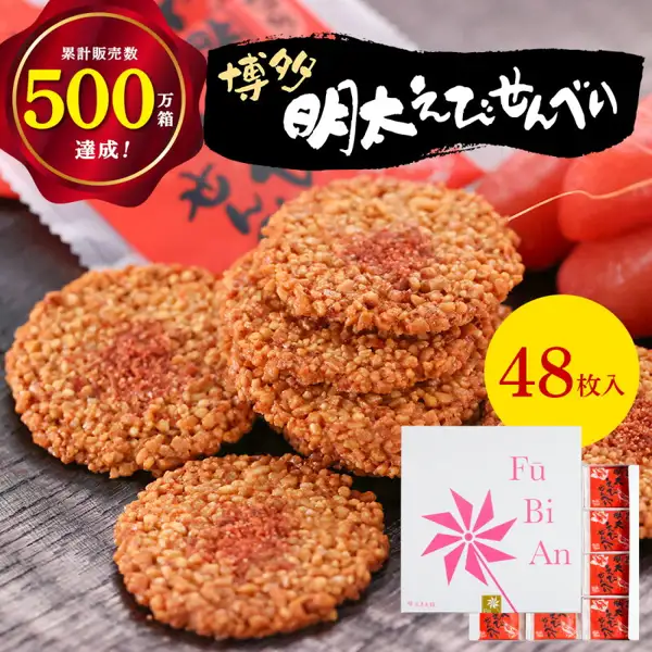 累計販売数500万箱達成と48枚入の表示がある、博多風美庵 博多明太えびせんべいの商品写真。明太子パウダーをのせた丸いえびせんべいと、赤い包装の袋、白い化粧箱が写っている。店舗が画像に入れた表示「累計販売数500万箱達成！」「博多明太えびせんべい」「48枚入」