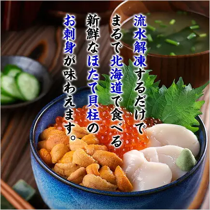 使用北海道产 訳あり 生ほたて貝柱（生扇贝柱）1kg（甲羅組）制作的海鲜盖饭装盘示例照片。蓝色碗中放有海胆、鲑鱼子、扇贝柱3颗、紫苏叶和山葵。后方是一碗汤，左侧是盛有黄瓜的小碟。图片内店铺放入的标示为“流水解凍するだけでまるで北海道で食べる新鮮なほたて貝柱のお刺身が味わえます。”。此为装盘示例，海胆、鲑鱼子、紫苏叶、山葵、汤和黄瓜不包含在商品内。