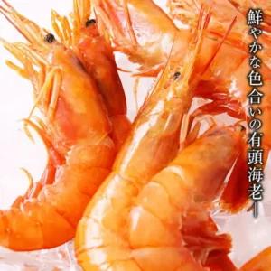 氷の上に重なった有頭の赤えびを近づけて写した、魚耕 天然赤えび 有頭 2kg（アルゼンチン産）の商品写真。画像内に店舗が画像に入れた表示として、「鮮やかな色合いの有頭海老」の文字あり