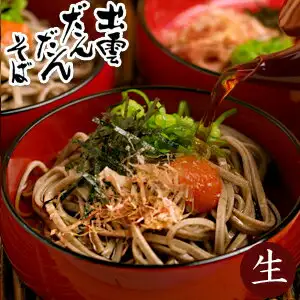 赤い器に盛ったゆでたそばに、刻みのり・刻みねぎ・かつお節・赤い薬味をのせ、上からつゆを注いでいる写真（本田商店 出雲だんだんそば 6人前）。奥にも同じ赤い器が2つ写っています。店舗が画像に入れた表示として「出雲だんだんそば」「生」の文字