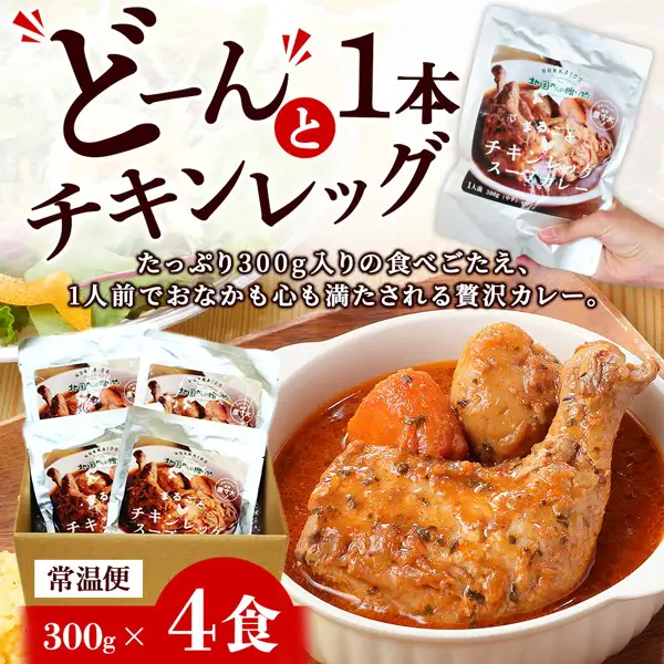 北国 まるごとチキンレッグスープカレー（整只鸡腿汤咖喱）4份装的商品照片。画面中有白色餐碗盛装的带骨鸡腿、胡萝卜、土豆汤咖喱，纸箱中装有4袋蒸煮袋，以及一只手拿着其中一袋。店铺在图片中加入的标示有「どーんと1本チキンレッグ」（整整一只鸡腿）「たっぷり300g入りの食べごたえ、1人前でおなかも心も満たされる贅沢カレー。」（足量300g，一人份即可满足的奢华咖喱）「常温便」（常温配送）「300g×4食」（300g×4份）等文字