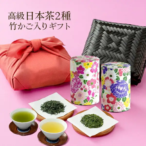 Photo showing a rose-colored furoshiki bundle, a black bamboo basket, two floral tea tins, tea leaves on paper and two cups of brewed tea (川本屋茶舗 autumn kuradashi new tea and Kakegawa tea bamboo basket set). Text the store placed in the image: “高級日本茶2種 竹かご入りギフト”