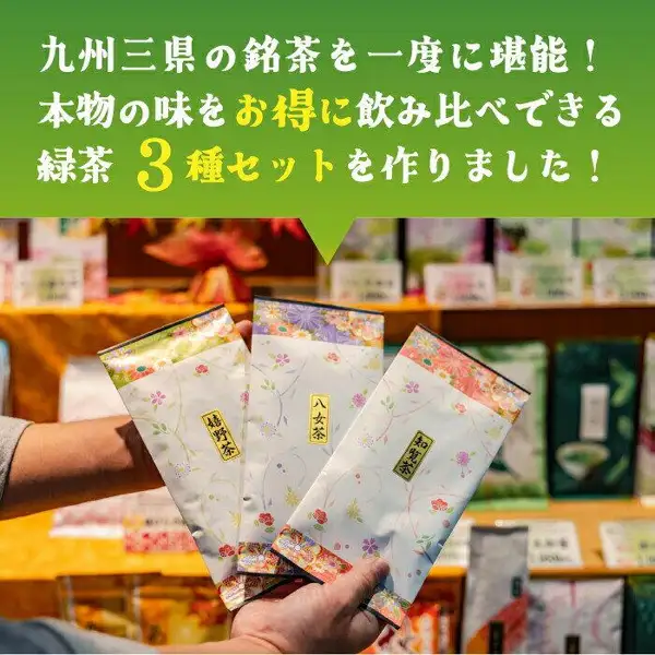 Product photo of three green tea bags labeled Ureshino tea, Yame tea and Chiran tea, held in a hand in front of tea shop shelves. お茶のくわ乃園 (Ocha no Kuwanoen) green tea tasting set of 3 bags. Text the seller added to the image: “九州三県の銘茶を一度に堪能！” (Enjoy the renowned teas of three Kyushu prefectures at once!) and “本物の味をお得に飲み比べできる緑茶3種セットを作りました！” (We made a 3-variety green tea set to compare authentic flavors at a good value!)