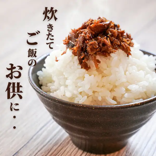 Product photo of brown, flaked tsukudani served on steaming white rice in a dark bowl. Vertical text on the left that the shop placed in the image reads “炊きたてご飯のお供に・・” (“A companion for freshly cooked rice”). Yaizu Specialty Tsukudani, Choose 2 or 3 Items