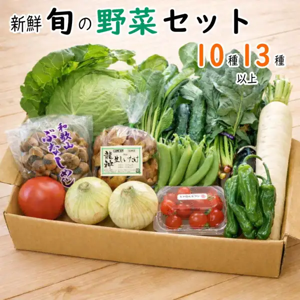 野菜詰め合わせセット 10種・13種以上の商品写真。木の台の上の段ボール箱に、キャベツ、大根、トマト、玉ねぎ2個、ミニトマトのパック、スナップえんどう、ししとう、きゅうり、袋入りのしめじと生しいたけなどの野菜が入っている。店舗が画像に入れた表示「新鮮 旬の野菜セット」「10種 13種 以上」、袋の表示「和歌山 ぶなしめじ」「龍神 生しいたけ」