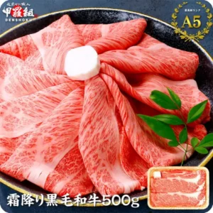 Product photo of Kouragumi domestic Kuroge Wagyu slices, 500g: thin slices of beef spread in a black bowl with a green leaf garnish, and a small photo of sliced beef in a tray at the lower right. Text the shop placed in the image: the shop logo "越前かに職人 甲羅組 DENSHOKU", a laurel badge reading "最高級ランク A5", and "霜降り黒毛和牛500g"