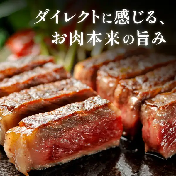 米沢牛黄木 サーロインステーキ（西冷牛排）180g×2枚的烹调示例照片：烤好后切成块的牛排，表面带有焦色，切面呈红色。背景隐约可见类似配菜的绿色和红色蔬菜，但并不包含在商品中。图中文字为店铺自行加入的标示，上方写有“ダイレクトに感じる、お肉本来の旨み”。