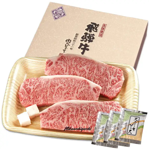 飛騨牛 サーロインステーキ 計500g（165g位×3枚）の商品写真。木目調のトレイに生のサーロインステーキ3枚と付属のステーキソース3袋がのり、後ろに化粧箱が立てかけられている。画像内の文字は店舗が入れた表示で、箱に「美味歓饌」「飛騨牛」「創業昭和三十一年 肉のひぐち」の文字と小さな奉納のマーク、写真の下部に「Nikunohiguchi」の署名風の文字がある。