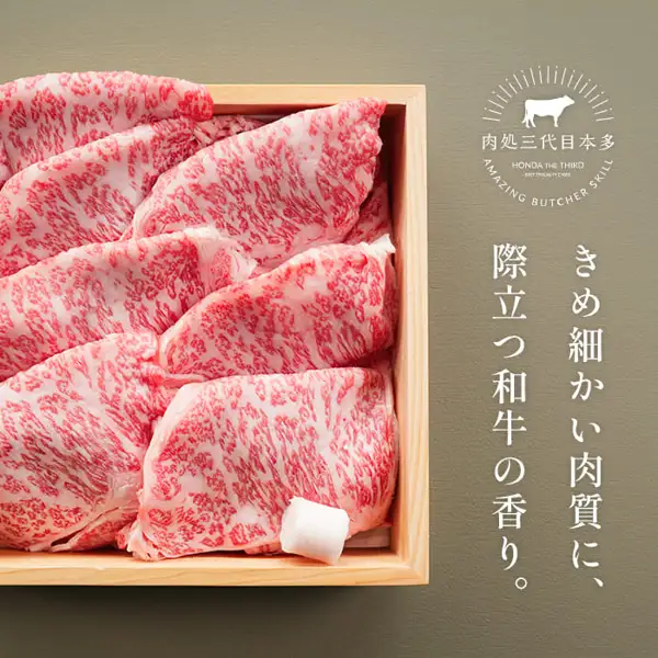 木箱中层叠排列着带雪花纹的牛肩里脊肉片,肉処 三代目本多 国产黑毛和牛 メガ盛肩ロースすき焼きスライス 1kg的商品照片。右侧为店铺徽标(肉処三代目本多)及店铺自行加入图片的标示「きめ細かい肉質に、際立つ和牛の香り。」(肉质细腻,和牛香气突出)