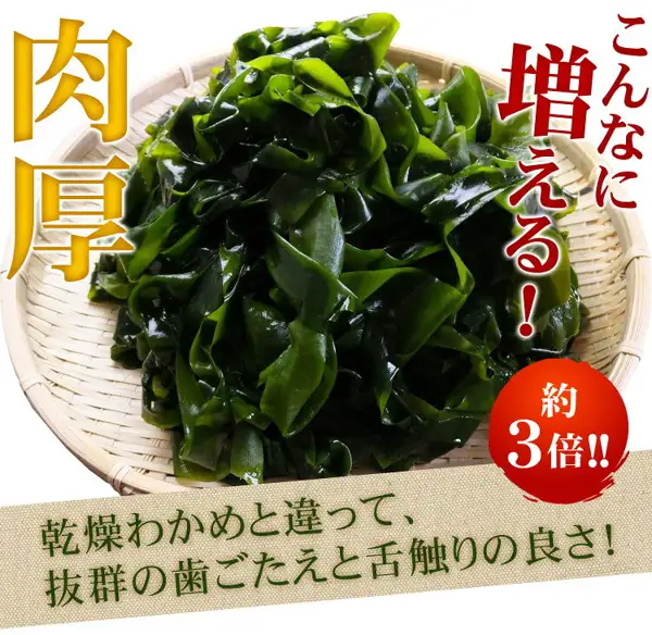 Photo of wide green wakame piled on a bamboo sieve. The upper left reads “肉厚”, the upper right reads “こんなに増える！”, a red circle at the lower right reads “約3倍!!”, and the band at the bottom reads “乾燥わかめと違って、抜群の歯ごたえと舌触りの良さ！” (text the shop placed in the image). 黒潮海苔店 Blanched and Salted Wakame 300g, Sanriku-labeled (produced in Noda Village, Iwate Prefecture)