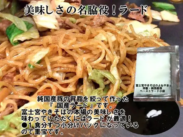 富士宮やきそばの炒め物を背景に、「富士宮やきそばのよねやま 特製・純国産豚 ペーストラード小袋」と書かれた銀色の小袋と、鉄板に出した少量の白いラードを重ねた写真。店舗が画像に入れた表示「美味しさの名脇役！ラード」「純国産豚の背脂を絞って作った『 国産ラード 』です。富士宮やきそばの本場の美味しさを味わっていただくにはラードが最適！●1食分ずつ小分けパックになっているので重宝です。」。特選 富士宮やきそば 10人前セット