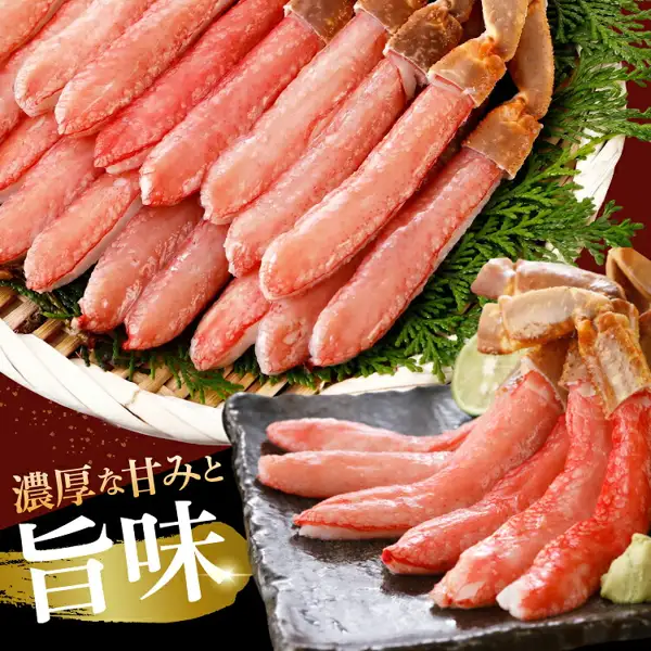 竹のざるに針葉樹の葉を敷いて殻つきの先端を残したずわいがにの棒肉を盛り、手前の黒い皿にも棒肉とライム、わさびを添えた商品写真（生本ずわいがに 棒肉ポーション）。画像内に店舗が画像に入れた表示として、「濃厚な甘みと旨味」の文字あり。ライム、わさび、針葉樹の葉は盛り付けの飾り。